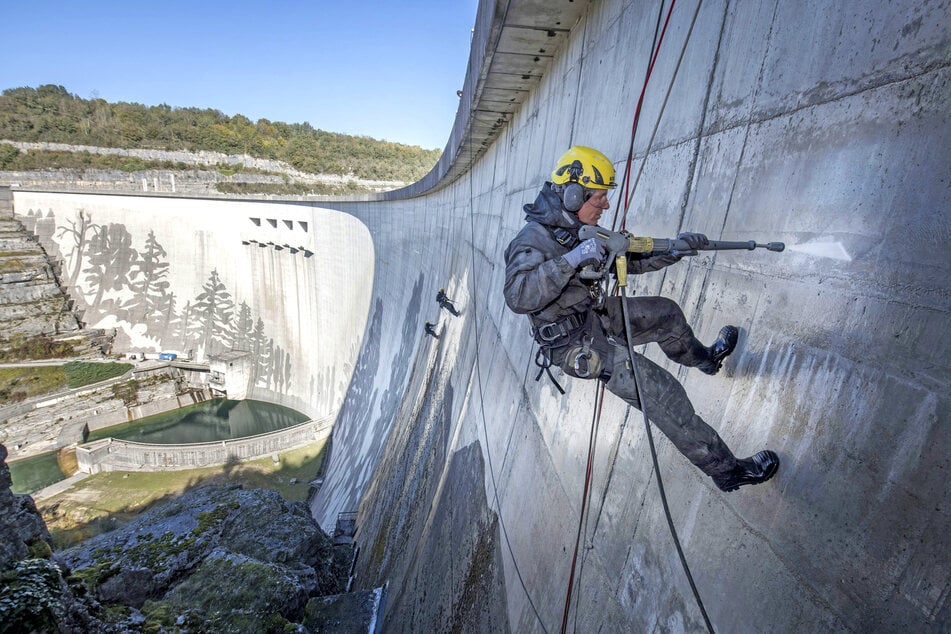 Graffiti, aber andersrum: Riesiges Kunstwerk entsteht auf Staumauer im Harz