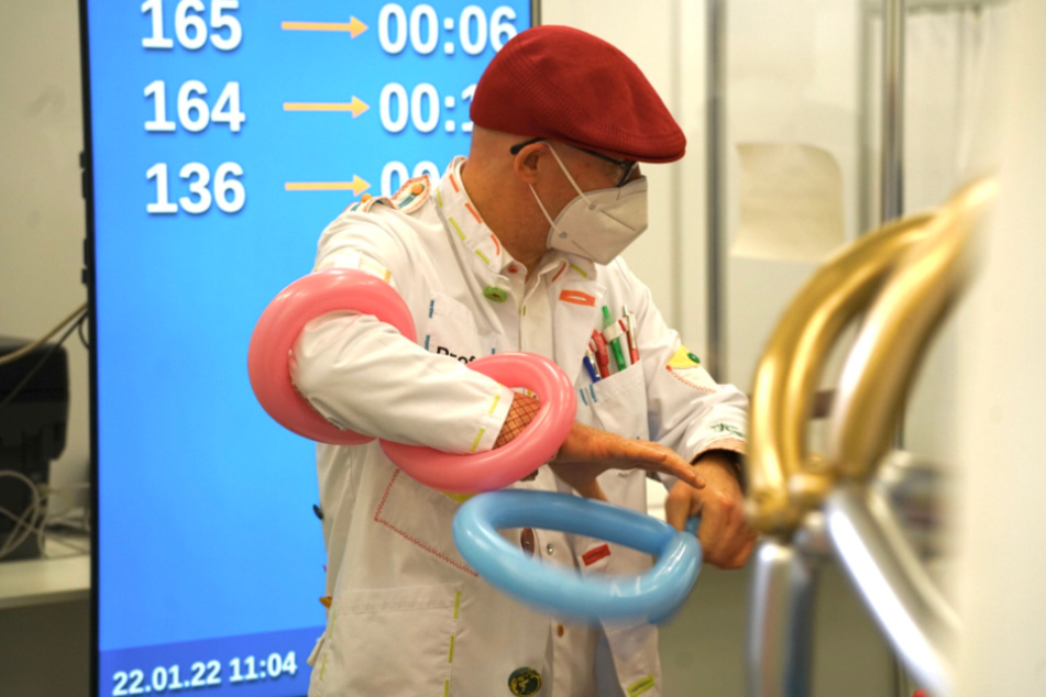 Mit farbenfrohen Luftballons zum vollständigen Impfschutz: Statt roter Nase trägt der Clown im größten Dresdner Impfzentrum eine rote Kappe.
