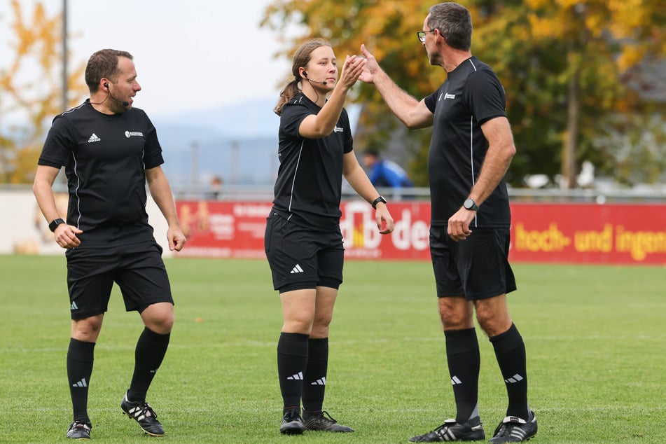 Die Schiedsrichterin Emma Sagasser (M.) klatscht ihren Vater Rainer Sagasser (r.) ab, links steht Assistent Tobias Fenkl.
