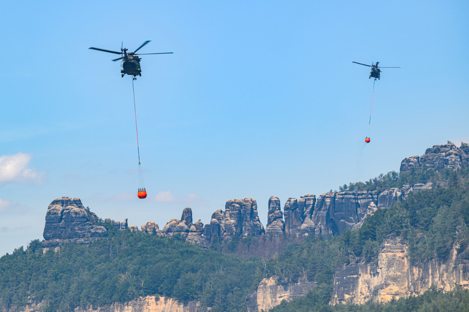 Am Donnerstagnachmittag sind weitere Hubschrauber mit Löschwasser-Außenlastbehältern unterwegs.