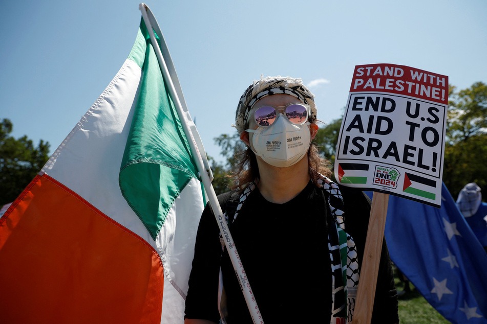 A protester holds a sign reading "Stand with Palestine! End US Aid to Israel!" outside the Democratic National Convention in Chicago, Illinois.