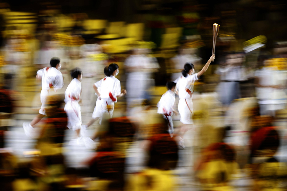 Torch-bearers running with the Olympic flame.