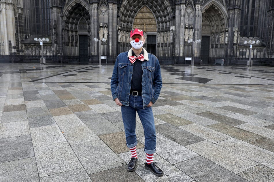 Ein Karnevalist vor dem Kölner Dom. Wegen Corona ist der Auftakt der Karnevalssaison am 11.11. abgesagt. Die Polizei und Feuerwehr berichten von null Einsätzen im Zusammenhang mit Karneval.