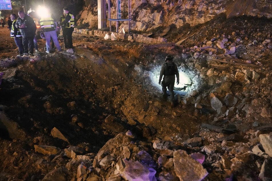 Hier war der Iran vor wenigen Tagen durchgekommen: Israelische Sicherheitskräfte inspizieren eine beschädigte Straße, nachdem eine vom Iran abgefeuerte Rakete in Jerusalem eingeschlagen ist.
