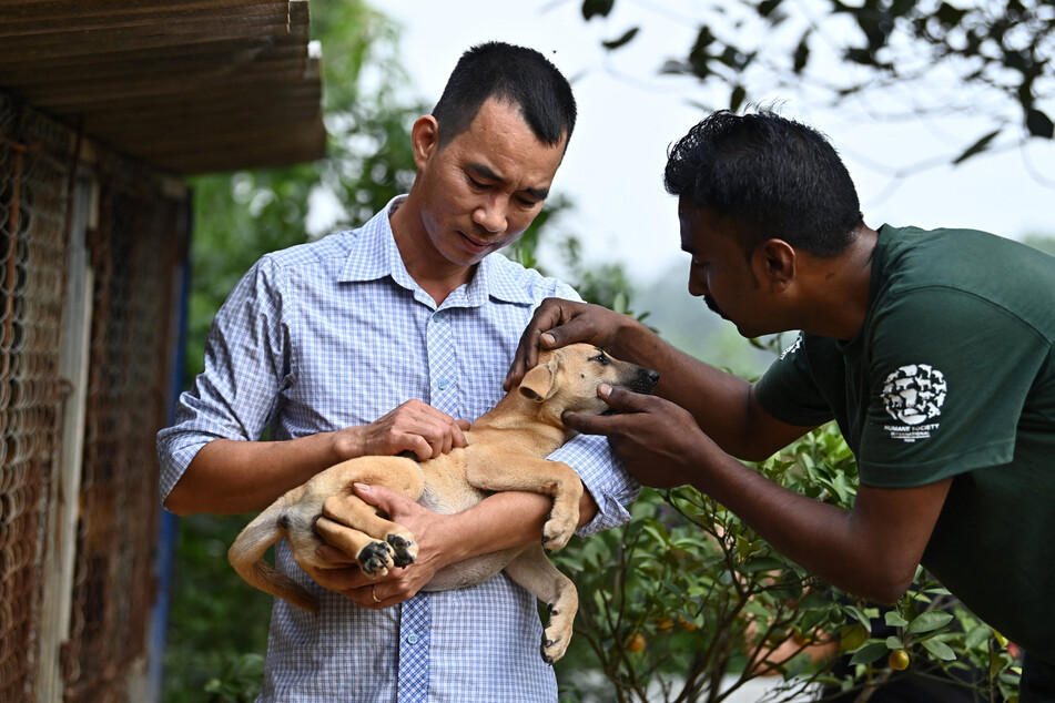 Schlachthaus-Betreiber Kieu Viet Hung (links) half mit, die Hunde an das Tierheim zu übergeben.
