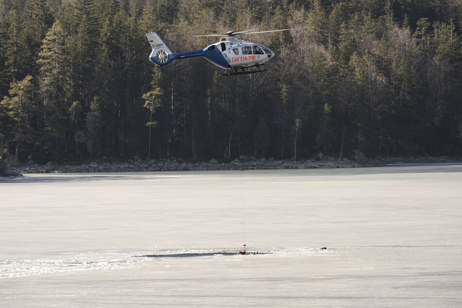 Retter wurden von einem Hubschrauber ins Wasser herabgelassen, um nach den Eingebrochenen zu suchen.