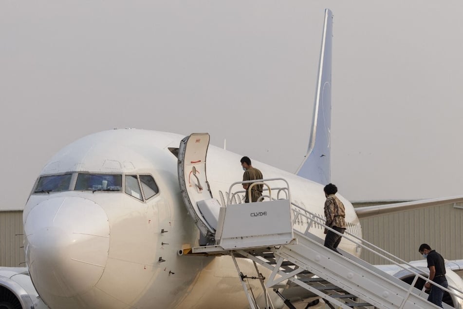 Shackled migrants detained by ICE board an airplane bound for Guatemala in Harlingen, Texas.