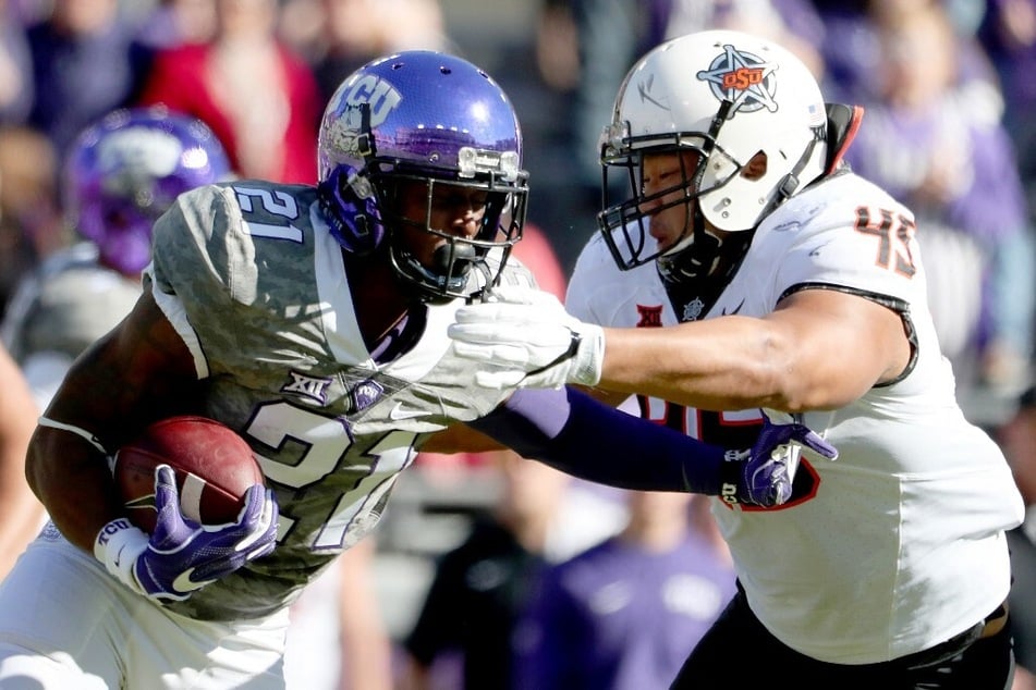 Kyle Hicks (l.) of the TCU Horned Frogs carried the ball against Chad Whitener of the Oklahoma State Cowboys in the teams' previous matchup from 2016.
