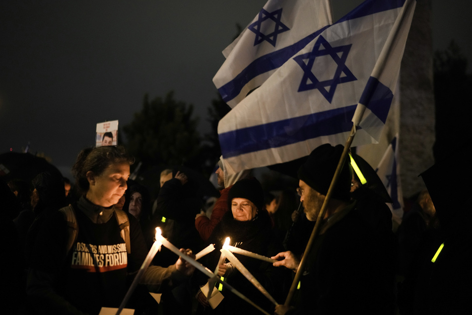 Angehörige und Freunde von Geiseln, die im Gazastreifen von der Hamas festgehalten werden, halten Kerzen und fordern ihre Freilassung während des jüdischen Chanukka-Festes. (Symbolbild)