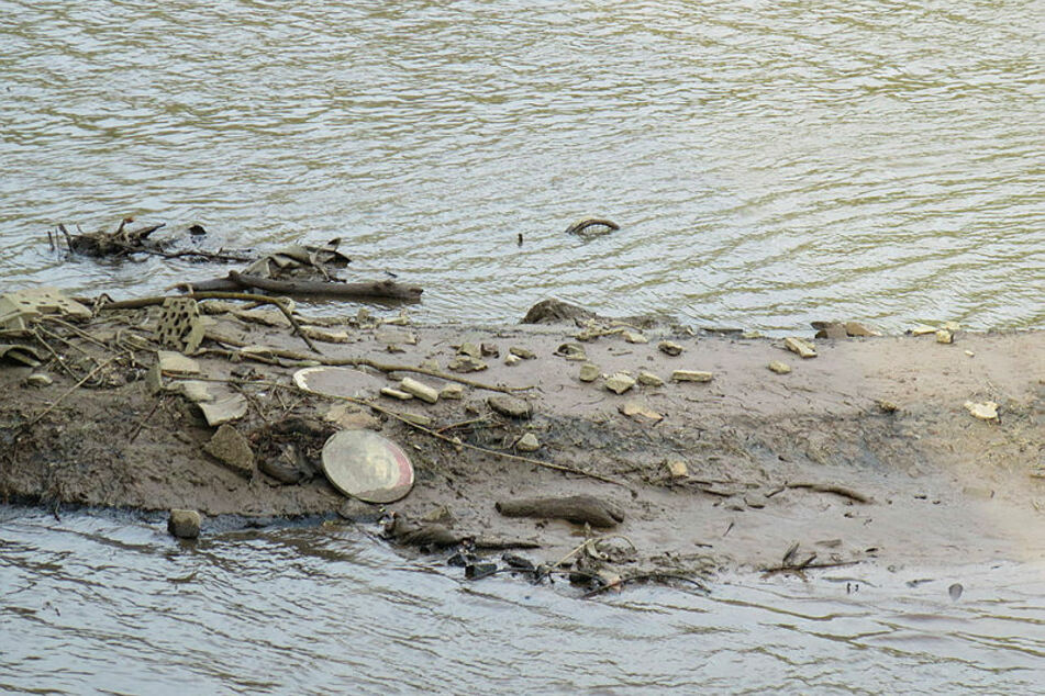 Wird der Wasserstand zur Wartung des Wehrs gesenkt, tauchen überall im Becken Schlamm- und Müllinseln auf.