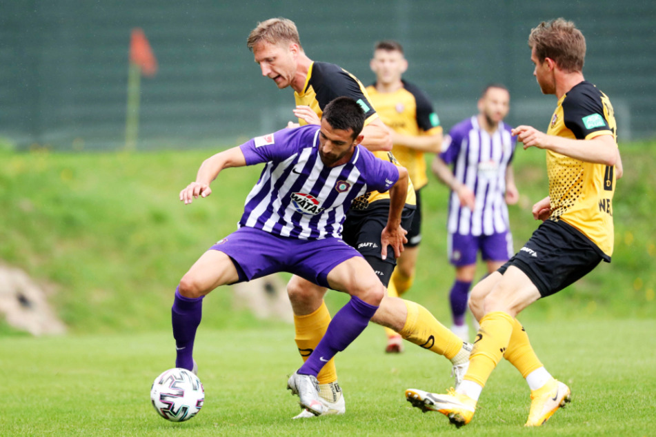 Die Dresdner Marco Hartmann (M.) und Patrick Weihrauch (r.) attackieren Aues Ognjen Gnjatic.