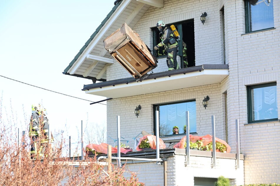 In der oberen Etage dieses Einfamilienhauses in Stollberg (Erzgebirge) brannte es am Donnerstagmorgen. Die Feuerwehr warf eine verbrannte Couch vom Vordach.