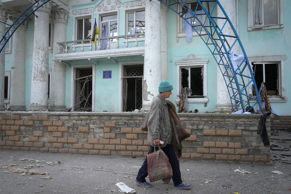 Eine Frau geht in der Nähe eines bei einem russischen Luftangriff zerstörten Gebäudes in Lyssytschansk vorbei.