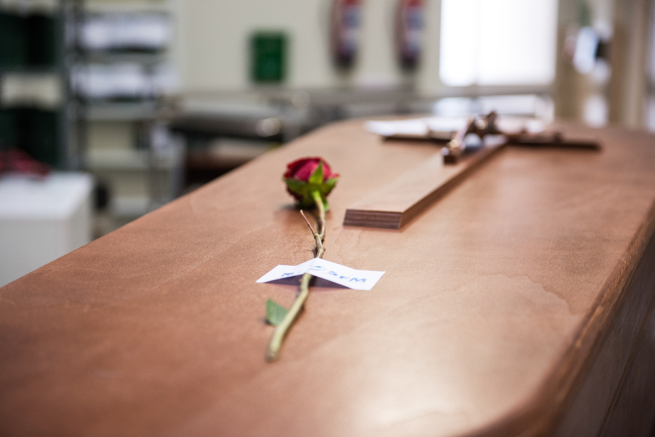 Eine Rose liegt auf einem Sarg, bevor er auf dem Friedhof La Almudena in Madrid eingeäschert wird.