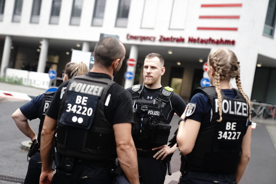 Polizeibeamte stehen vor der Einfahrt zur Charité. Hier wird der russische Oppositionellen Nawalny erwartet.