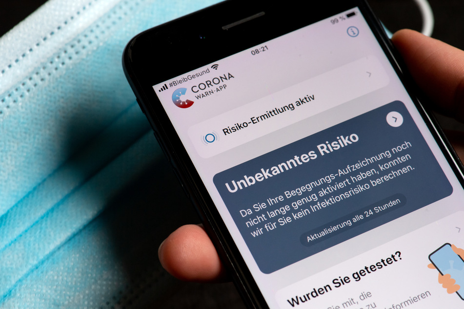 Die offizielle Corona-Warn-App zeigt auf einem Smartphone eine Risiko-Ermittlung an.