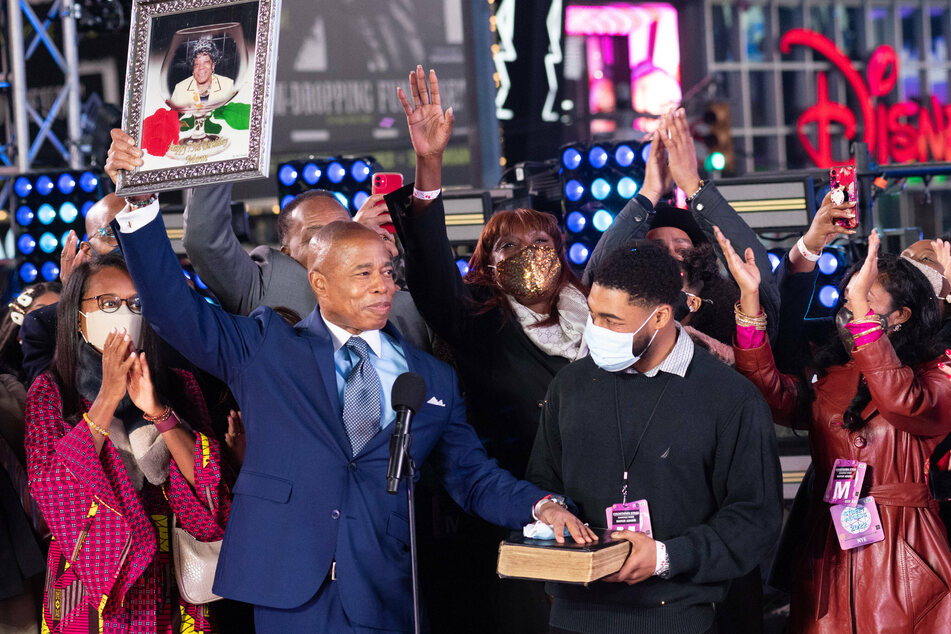 Eric Adams held up a framed photo of his late mother as he recited the oath of office on the main riser in Times Square before thousands of New Year’s Eve revelers, immediately after the ball dropped.