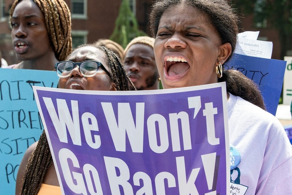 A student holds a sign reading "We Won't Go Back!" during a protest at Harvard University.