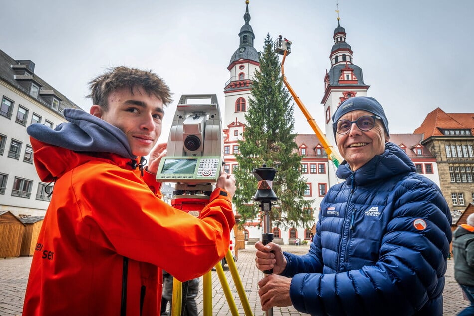 Julian Rielemann (16, l.), Azubi im ersten Lehrjahr bei Wuttke Ingenieure, und Detlev Wuttke (63) vermessen den Chemnitzer Weihnachtsbaum auf dem Markt.