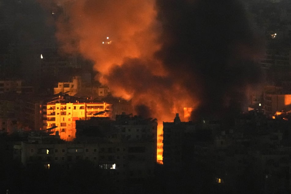 Flammen und Rauch steigen von Gebäuden auf, die von israelischen Luftangriffen auf einen südlichen Vorort von Beirut am frühen Sonntag getroffen wurden.