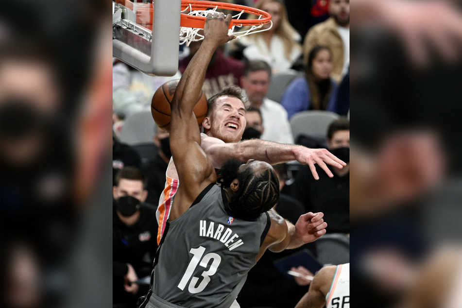 The Nets' James Harden scoring past Spurs forward Jakob Poeltl.