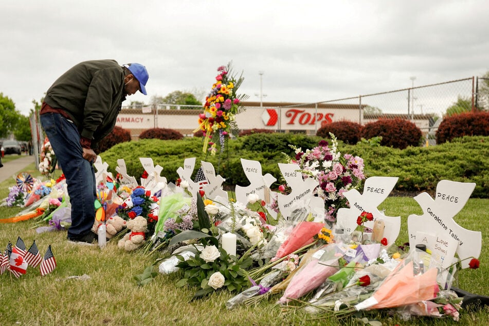 A man mourns at a memorial outside the scene of a mass shooting at a Tops supermarket in Buffalo, New York.