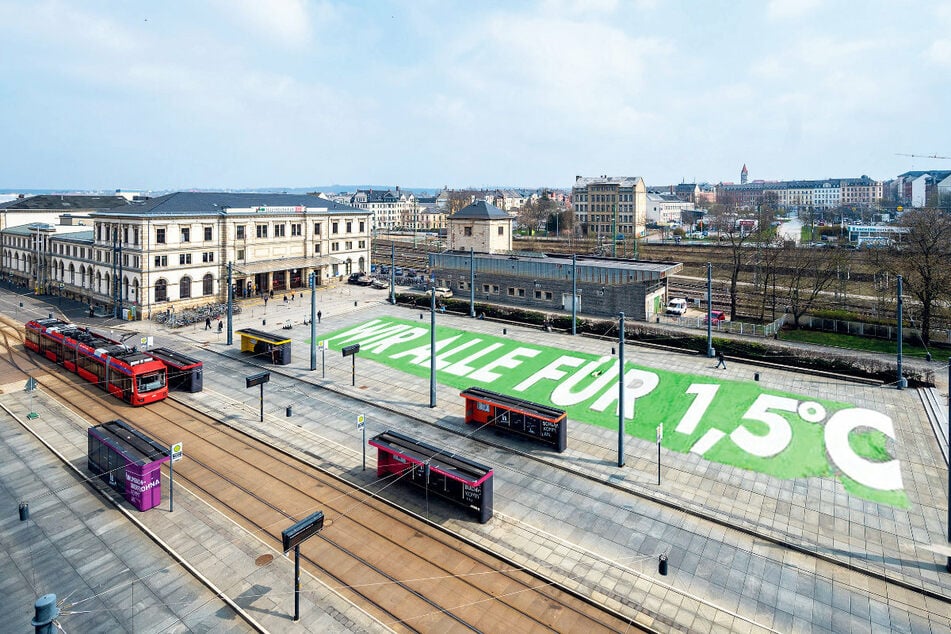 Auf dem Bahnhofsvorplatz wünschen sich Klimaaktivisten ein riesiges Boden-Banner.