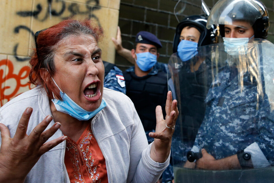 Eine regierungskritische Demonstrantin mit medizinischem Mundschutz schreit während Zusammenstößen mit der Bereitschaftspolizei bei einem Protest gegen die landesweite wirtschaftliche Krise vor dem Wirtschaftsministerium.
