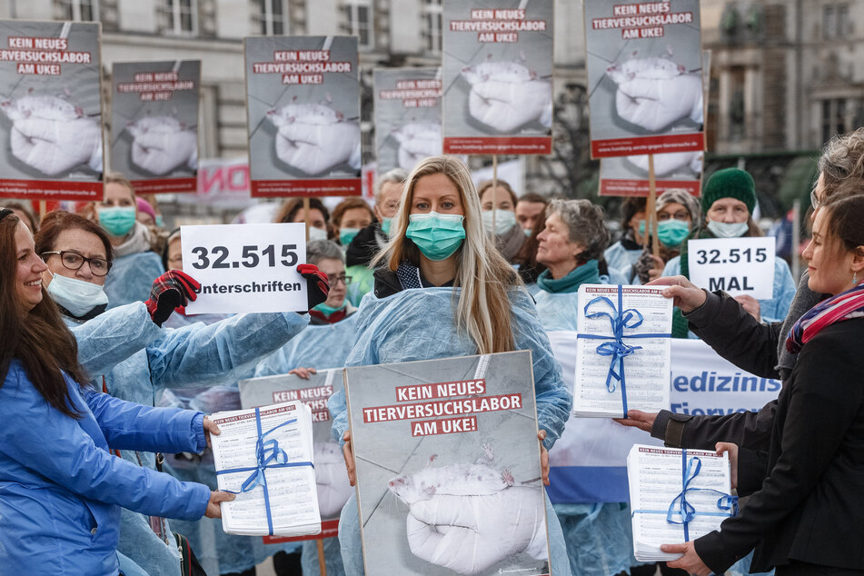 Eine Aktivistin des Vereins Ärzte gegen Tierversuche hält während einer Demonstration gegen ein geplantes Tierversuchslabor am UKE ein Plakat.